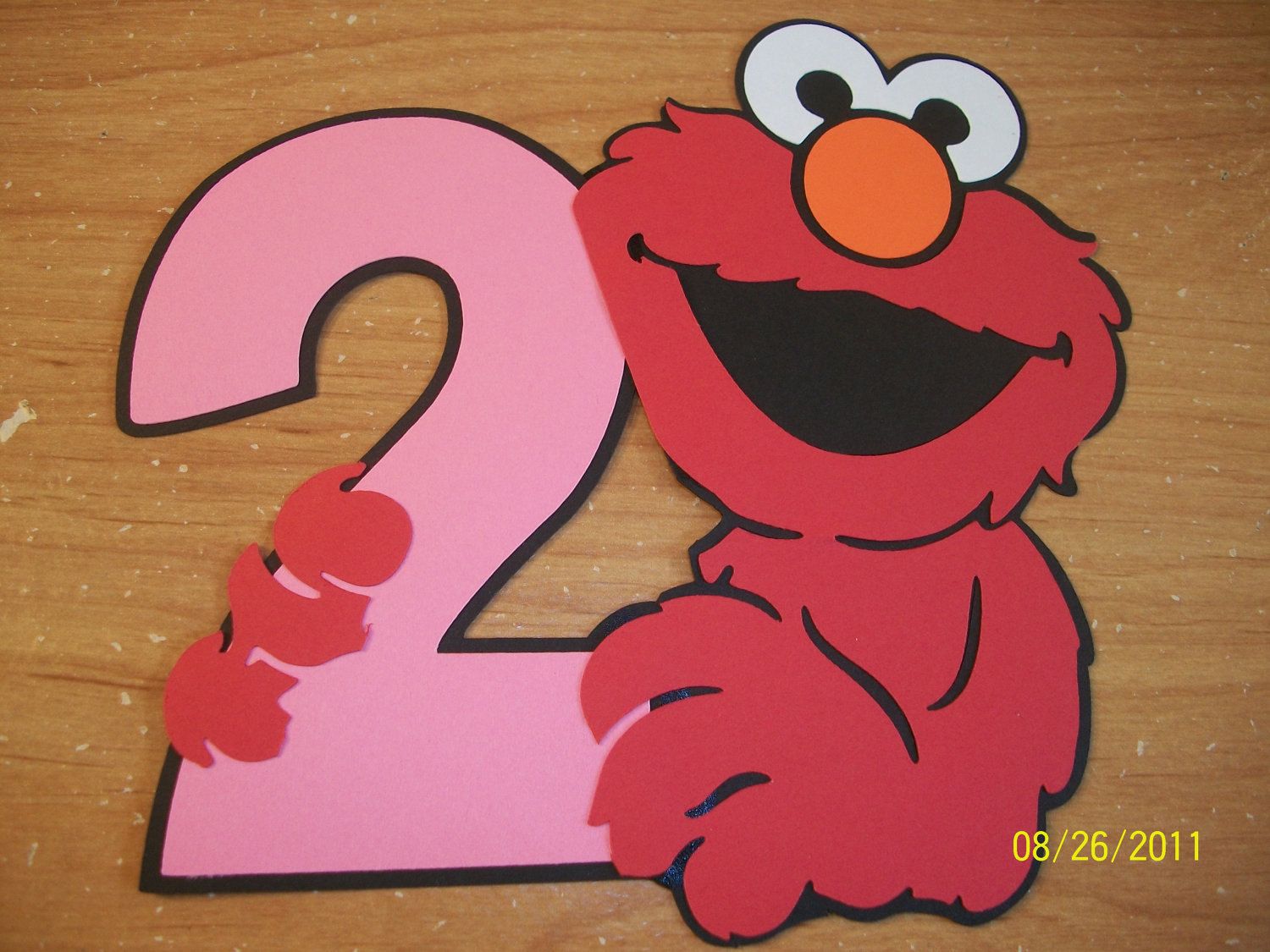 Elmo holding a number
