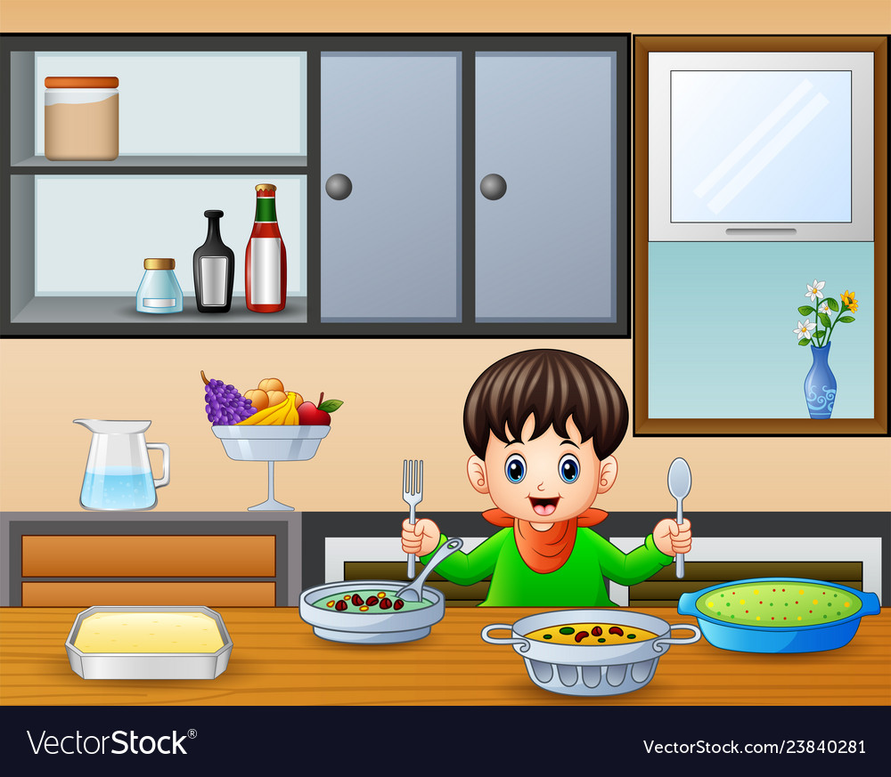Happy little boy holding spoon and fork eating at